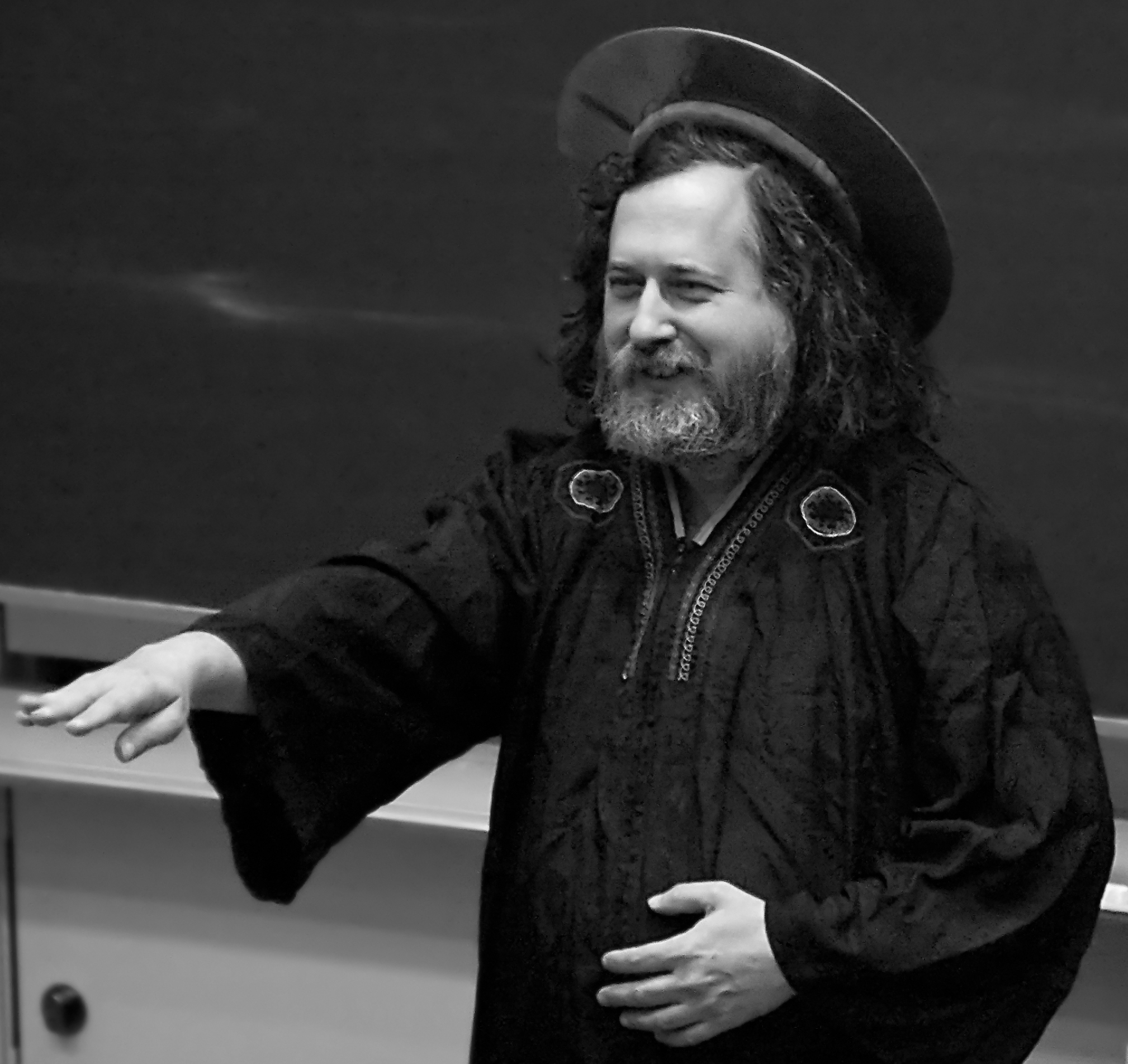 Richard Stallman utklädd till S:t IGNUcius i vit dräkt med halo av optisk skiva.